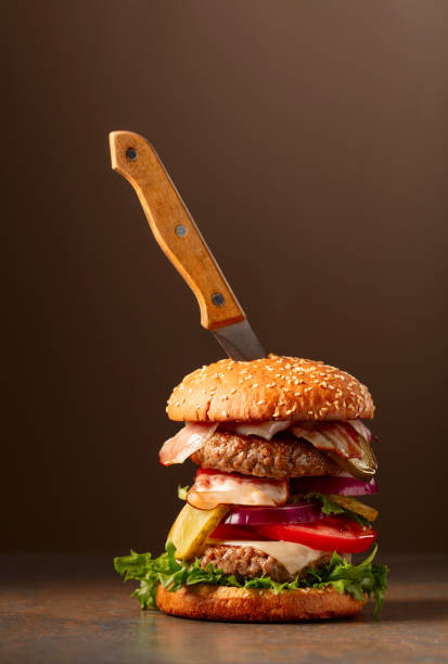 istock Fresh burger with knife on a brown background. 1839427259