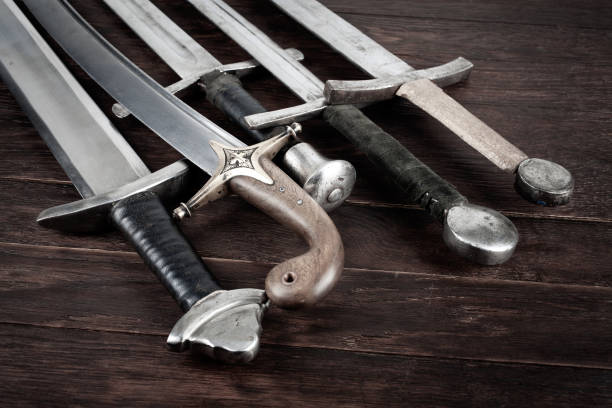 istock Swords and sabre on wooden background. 1839442589