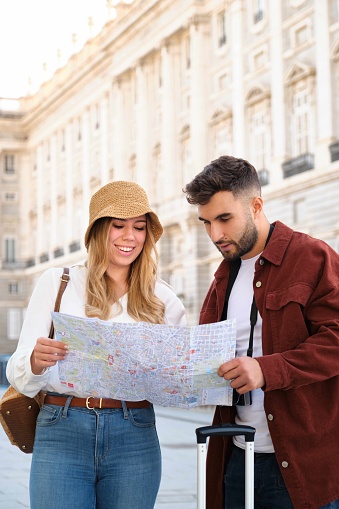 Young Caucasian couple check the map to prepare a tour to visit Madrid, Spain.