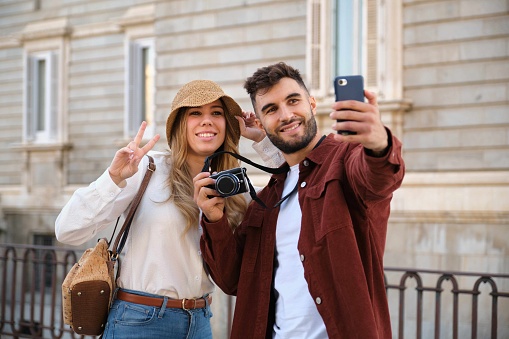 Young Caucasian tourist taking a selfie while sightseeing Madrid, Spain.