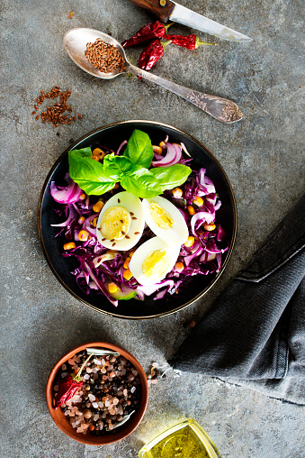 Cabbage salad with corn and boiled egg on plate