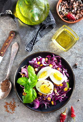 Cabbage salad with corn and boiled egg on plate