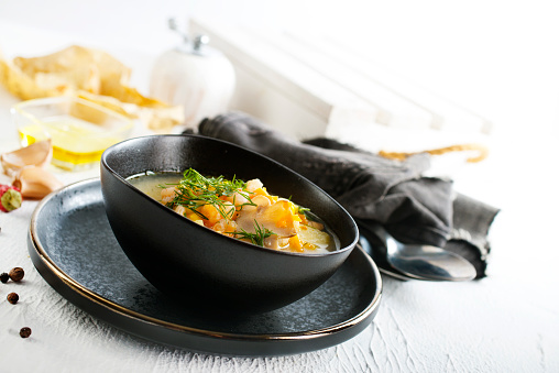 Pea soup with pieces of bacon and parsley in a bowl