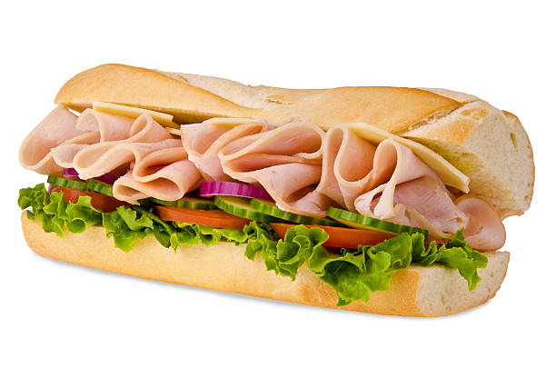 A sub sandwich overflowing with ham Huge sub sandwich isolated on white background. submarine photos stock pictures, royalty-free photos & images