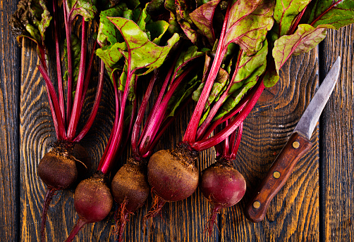 fresh beets on cutting board, set on wooden table