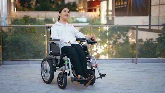 Asian disabled business woman on wheelchair commuting to work