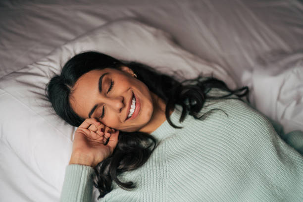 istock Charming young woman lying in bed at home 1839549228