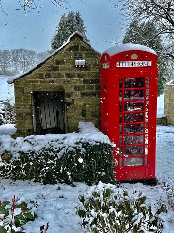 Red English telephone box in rural snowy scenery