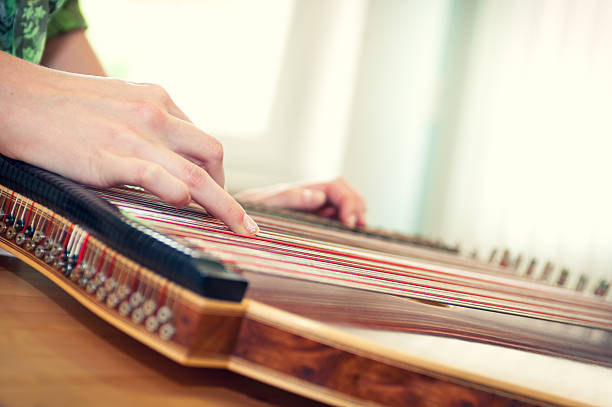 Close up of a young girl's hand playing on zither Close up of a young girl's hand playing on zither - musical instrument with strings. psaltery stock pictures, royalty-free photos & images