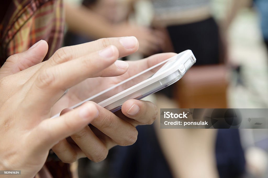 Teenage girl using white mobile phone Teenage girl text messaging on her phone  Adult Stock Photo
