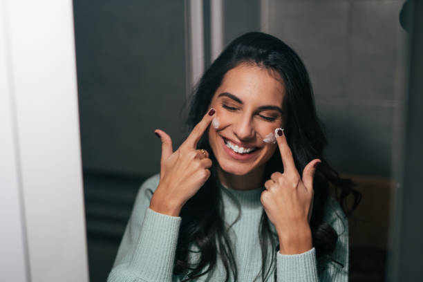 istock Young woman applying moisturizer on her face 1839643403