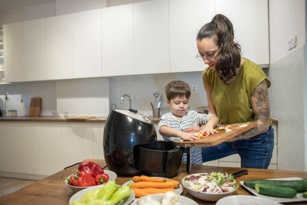 istock Cute boy cooking vegetables with his mom 1839643933
