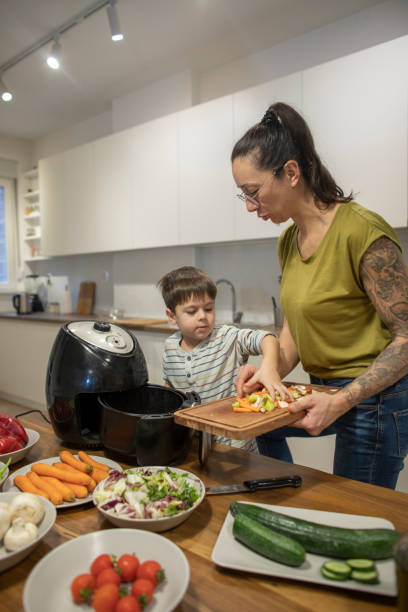 istock Woman and her little son making vegetable meal 1839643935
