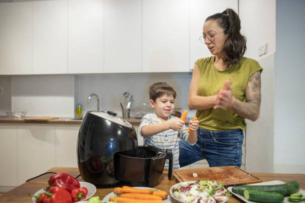 istock Happy little boy having fun making vegetable meal with mom 1839643943
