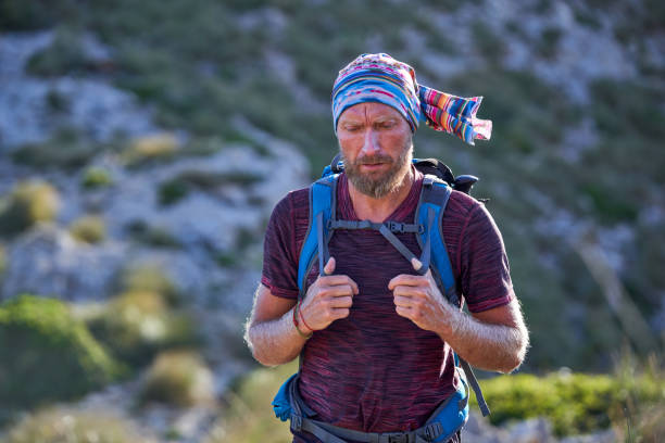 male hiker with backpack on hillside - explorer tourist frowning men imagens e fotografias de stock