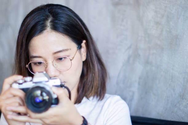 istock Beautiful cute woman photographed on a mirrorless camera. Selective focus image. 1839665814