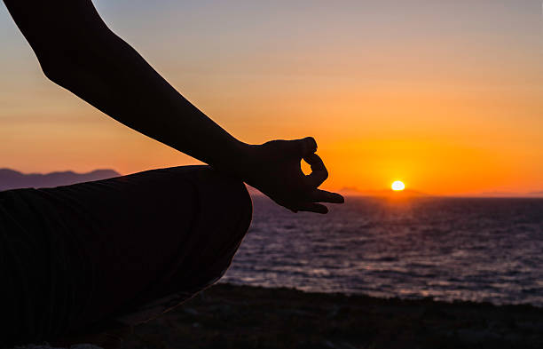 Silhouette in yoga lotus position stock photo