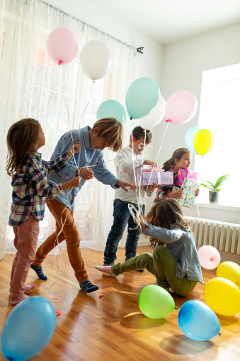 Group of children dancing and having fun on a indoors Birthday party
