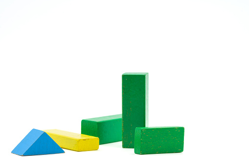 Colorful wooden blocks lying and standing. Cuboid and triangle, in green, yellow and blue blocks isolated on a white background.