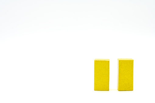 Two yellow wooden blocks standing isolated on a white background