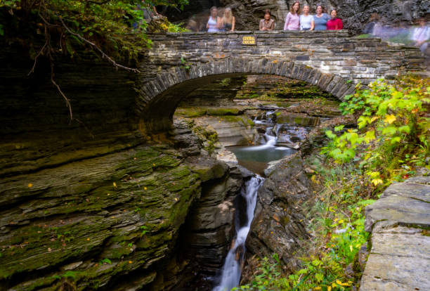 Autumn in Watkins Glen State Park, near Seneca Lake, New York State, USA.  There are people on the bridge over the gorge.