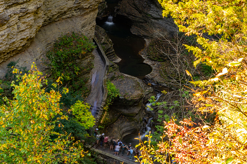 Autumn in Watkins Glen State Park, near Seneca Lake, New York State, USA.  There are people on the bridge over the gorge.