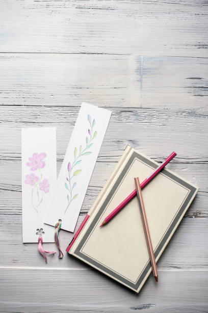 istock Flat Lay Concept of Notebook with Blooming Bookmarks on White Wooden Background 1839728037