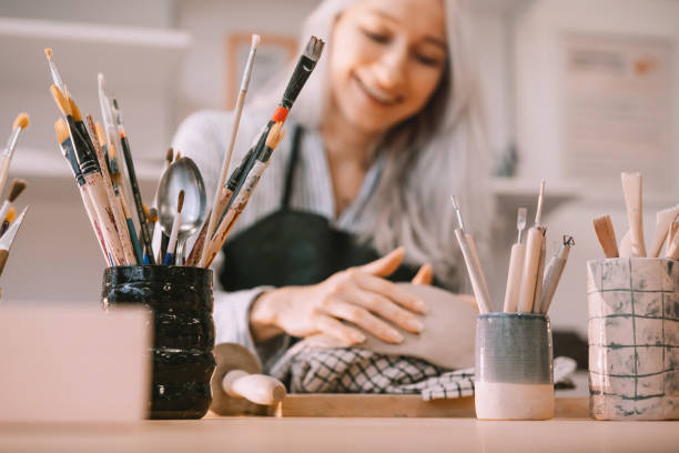 istock Female craftsperson working on ceramics tableware on pottery workshop. 1839740106