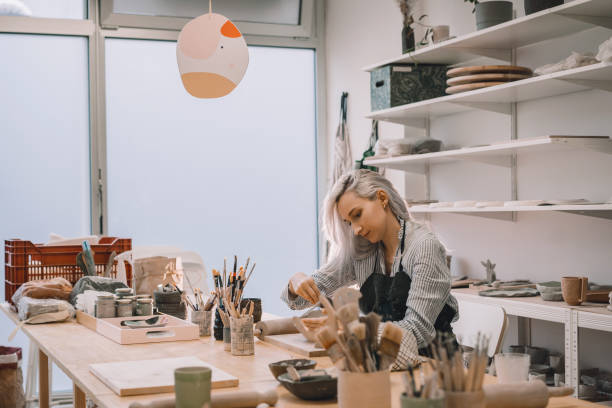 istock Female craftsperson working on ceramics tableware on pottery workshop. 1839740418