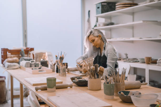 istock Female craftsperson working on ceramics tableware on pottery workshop. 1839740947