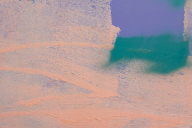 Messy paint strokes and smudges on an old painted wall background. Abstract wall surface with part of graffiti in purple, peach, green colors. Colorful drips, flows, streaks of paint and paint sprays