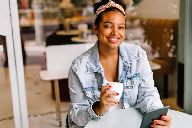 istock Young woman enjoying hot coffee and technology in cafe 1839763977