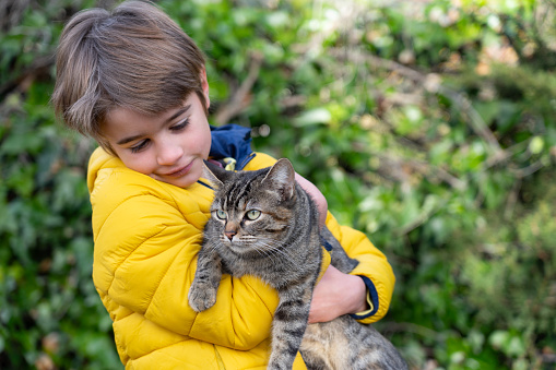 Boy holding his cat in his arms