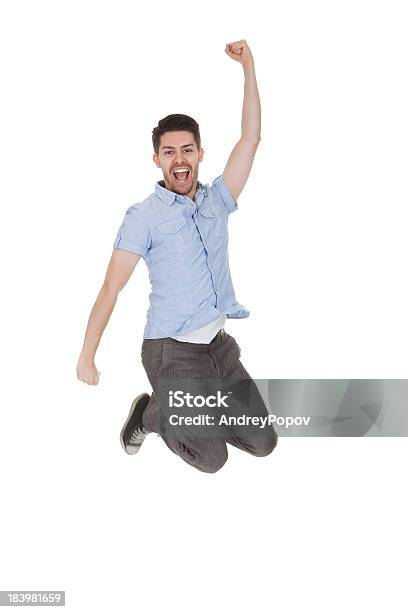 Young Man Jumping With Arms Raised Stock Photo - Download Image Now - Fashion, Achievement, Active Lifestyle