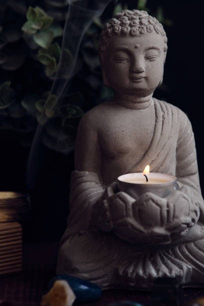 istock stone statue of buddha with a candle 1839823861