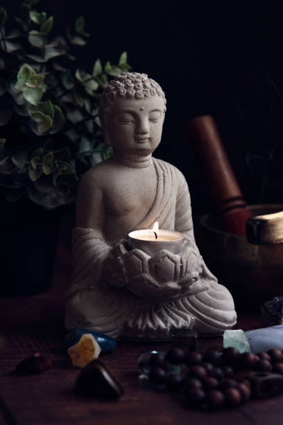 istock stone statue of buddha with a candle 1839824386