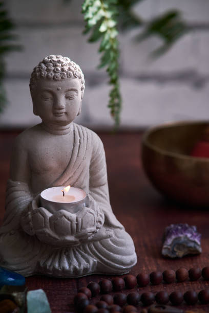 istock stone statue of buddha with a candle 1839825507