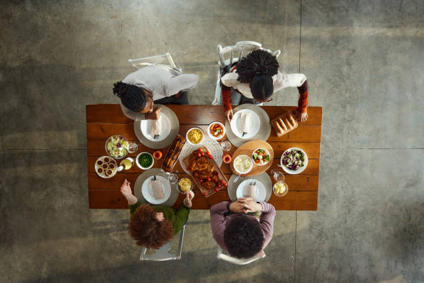 istock Above view of young friends having lunch at dining table. 1839830260