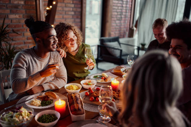 istock Young happy friends talking during dinner at dining table. 1839849149