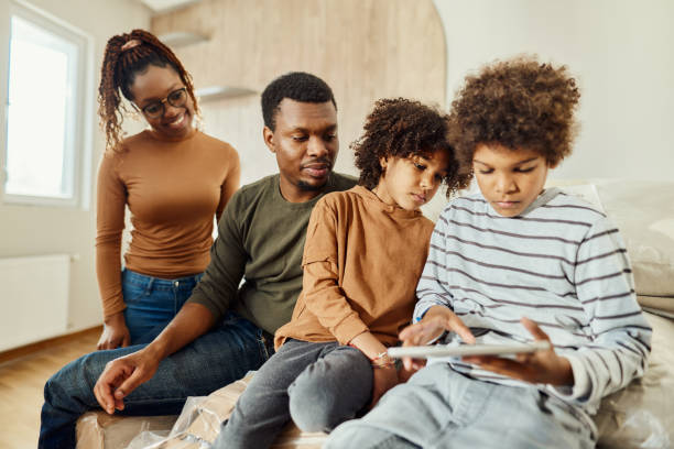istock African American family using touchpad in their new home. 1839851256