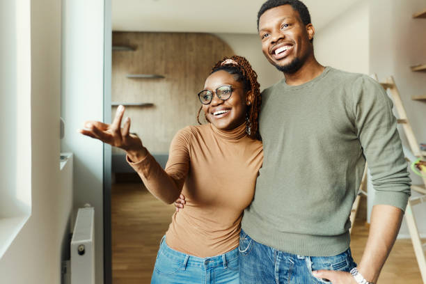 istock Happy black couple looking through window from a new apartment. 1839858224