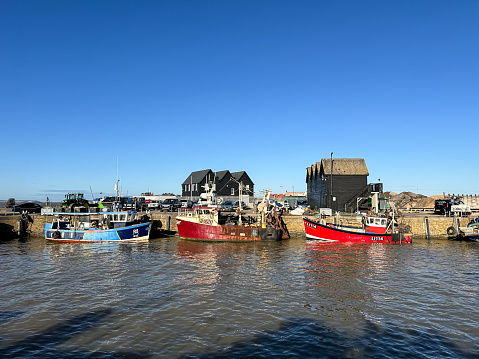 Whitstable, UK - 28.11.2023. Fishing boats moored at Whitstable harbor in Kent England. Sunny day in Whitstable