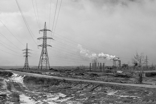 Power line in the middle of the field. Power station. Black and white photo.