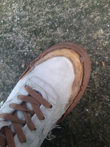 Dirty old work boots. shoes soiled in polyurethane foam in the process of warming the house. High quality photo