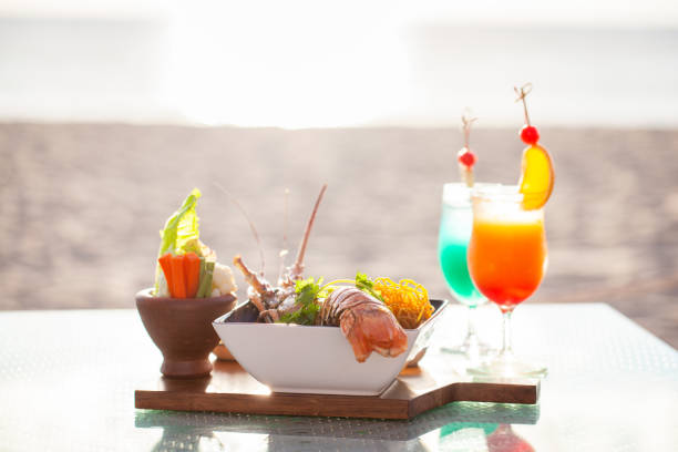 istock Beachfront dining experience with seafood platter and tropical cocktail. Gourmet cuisine and leisure. 1839894617