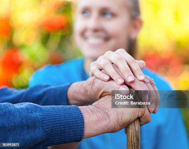Young Woman Doctor Helping A Senior Stock Photo - Download Image Now - Holding, Nurse, Patient