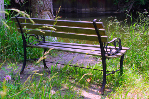 A park bench awaits the next angler coming to fish in the Clinton River, Michigan.