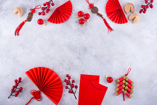 Chinese new year concept with red decoration. Money envelopes, tangerines, fans, fireworks and fortune cookies
