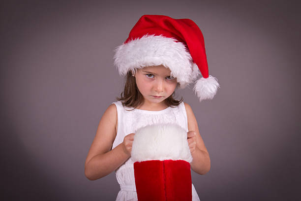Little girl disappointed with her Christmas stocking stock photo