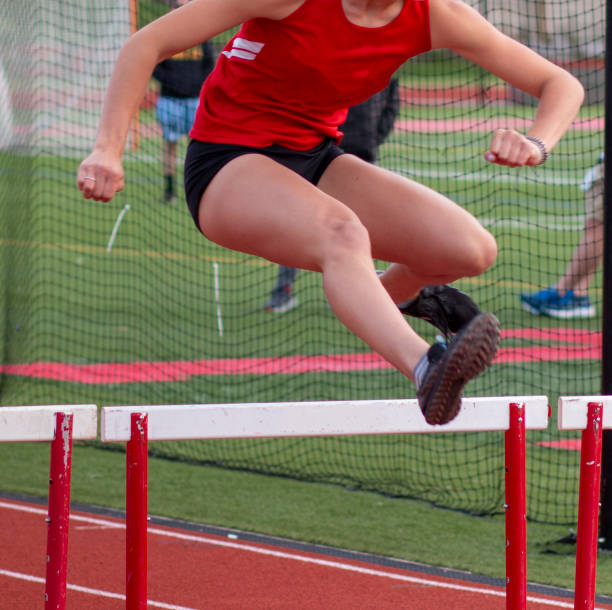 istock Woman Successfully Clearing a Hurdle on a Track 1839942592